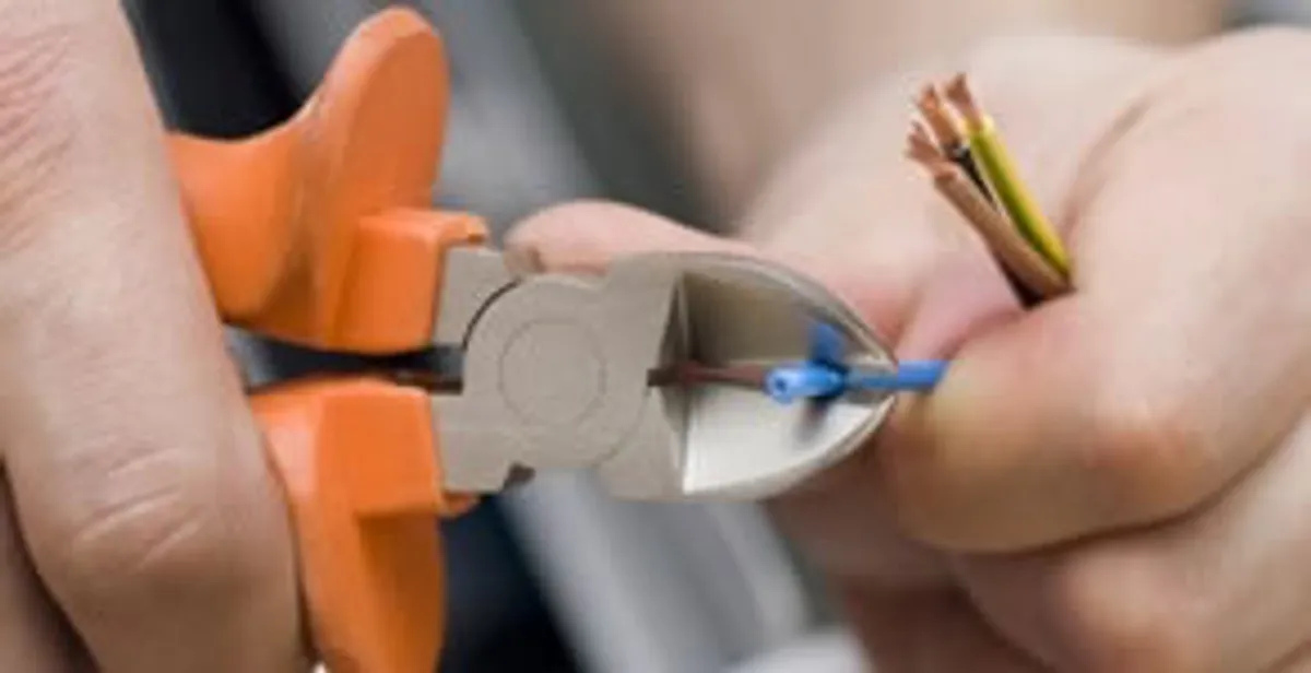 licensed electrician performing precise wire cutting and preparation during electrical service in Cincinnati, OH